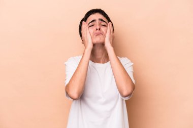 Beyaz tenli genç bir kadın bej arka planda izole edilmiş sızlanıyor ve ağlıyordu..