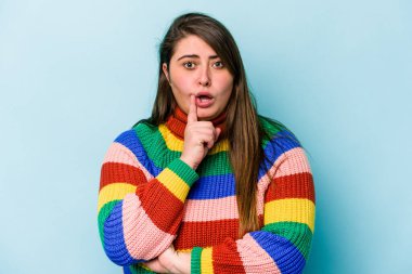 Mavi arka planda izole edilmiş beyaz, genç bir kadın. Harika bir fikri var, yaratıcılık kavramı..