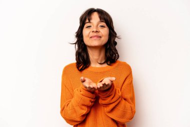 Beyaz arka planda izole edilmiş genç İspanyol kadın elinde avuç içi bir şeyle kameraya sunuyor..