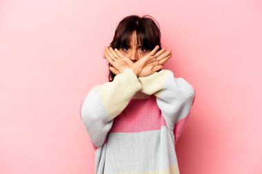 Pembe arka planda izole edilmiş genç İspanyol kadın inkar jesti yapıyor.