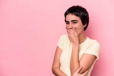 Pembe arka planda soyutlanmış genç beyaz kadın gülüyor, kaygısız, doğal duygu..