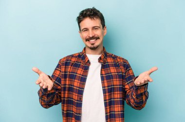 Mavi arka planda izole edilmiş beyaz bir genç hoş bir yüz ifadesi sergiliyor..