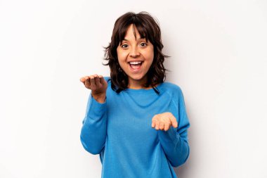 Beyaz arka planda izole edilmiş genç İspanyol kadın kollarıyla ölçeği yapıyor, mutlu ve kendinden emin hissediyor..