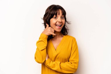 Beyaz arka planda izole edilmiş genç İspanyol kadın parmaklarıyla bir cep telefonu hareketi gösteriyor..