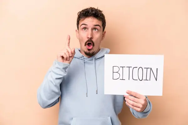 Junger Kaukasischer Mann Mit Einem Bitcoin Plakat Auf Beigem Hintergrund — Stockfoto