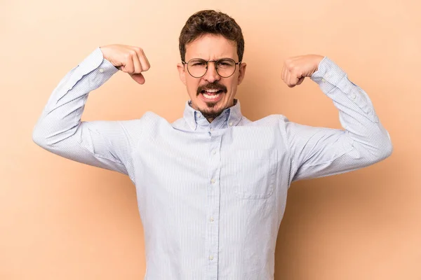 Joven Hombre Caucásico Aislado Sobre Fondo Beige Mostrando Gesto Fuerza — Foto de Stock