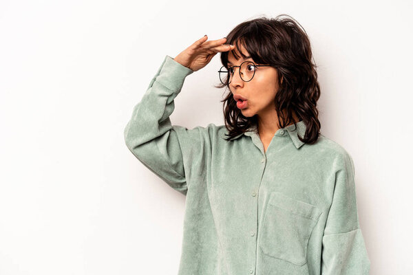 Молодая латиноамериканка, изолированная на белом фоне, держащая руку на лбу..