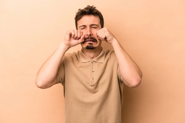 Junger Kaukasischer Mann Isoliert Auf Beigem Hintergrund Jammert Und Weint — Stockfoto