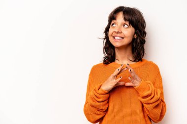 Latin kökenli genç bir kadın beyaz arka planda izole edilmiş bir plan kuruyor, bir fikir kuruyor..