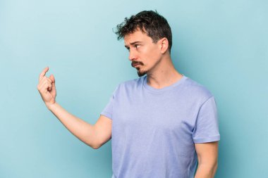 Kafkasyalı genç adam mavi arka planda izole edilmiş seni işaret ediyor sanki davet ediliyormuş gibi..