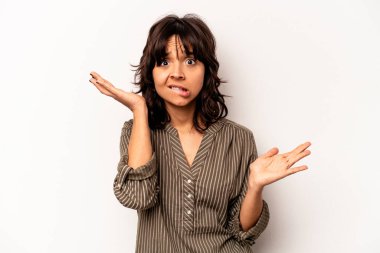 Beyaz arka planda izole edilmiş genç İspanyol bir kadın. Kafası karışmış ve omuz silkiyor. Kopya alanını tutmak için..
