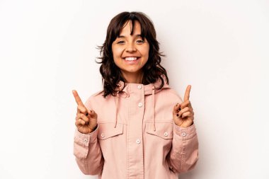 Beyaz arka planda izole edilmiş genç İspanyol kadın iki parmağı da boş bir alan gösteriyor..