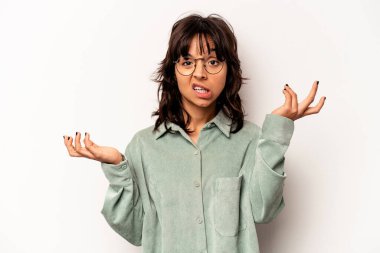 Beyaz arka planda izole edilmiş genç bir İspanyol kadın şüpheli bir tavırla omuz silkiyor..