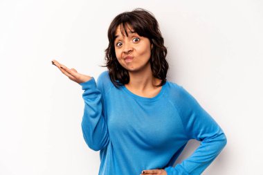 Beyaz arka planda izole edilmiş genç bir İspanyol kadın şüpheli bir tavırla omuz silkiyor..