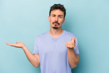 Kafkasyalı genç adam mavi arka planda izole edilmiş..