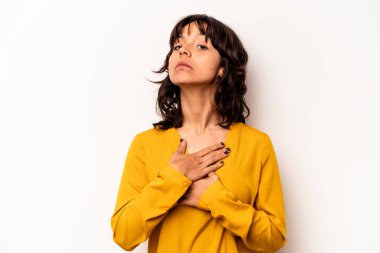 Beyaz arka planda izole edilmiş genç İspanyol kadın yemin ediyor, elini göğsüne koyuyor..