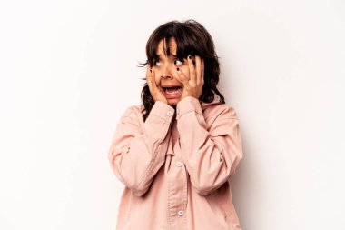 Latin kökenli genç bir kadın, beyaz arka planda izole edilmiş, kulaklarını elleriyle kapatmış, yüksek sesle sesler duymamaya çalışıyor..