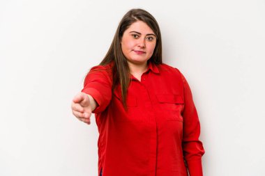 Beyaz arka planda izole edilmiş beyaz tenli genç beyaz kadın selamlaşma jesti olarak kameraya elini uzatıyor..