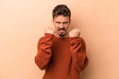Beyazlı genç adam bej arka planda izole edilmiş gergin elleriyle çığlık atıyor..