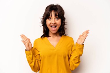 Beyaz arka planda izole edilmiş genç İspanyol kadın hoş bir sürprizle karşılaşıyor, heyecanlı ve el kaldırıyor..