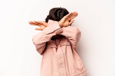 Beyaz arka planda izole edilmiş genç İspanyol kadın iki kolu çapraz tutuyor, inkar kavramı.