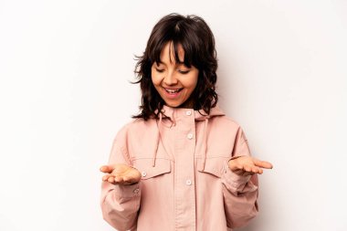 Beyaz arka planda izole edilmiş genç İspanyol kadın elinde avuç içi bir şeyle kameraya sunuyor..