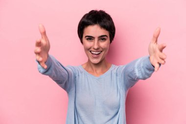 Pembe arka planda izole genç beyaz kadın zaferi ya da başarıyı kutluyor, şaşırıyor ve şok oluyor..