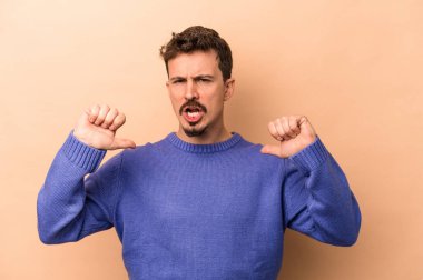 Beyazların arka planında izole edilmiş genç beyaz adam gururlu ve kendinden emin hissediyor, örnek olarak..