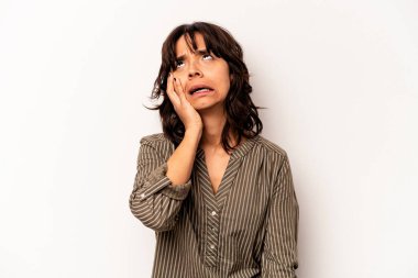 Beyaz arka planda izole edilmiş genç İspanyol kadın yorgun ve uykulu ellerini başının üstünde tutuyor..