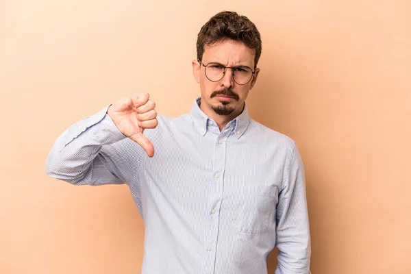 Young Caucasian Man Isolated Beige Background Showing Thumb Disappointment Concept — Stock Photo, Image