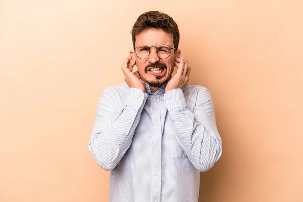 Hombre Joven Caucásico Aislado Sobre Fondo Beige Cubriendo Las Orejas — Foto de Stock