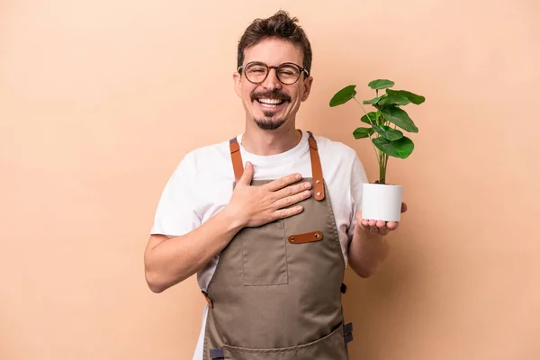 Junger Kaukasischer Gärtner Der Eine Pflanze Auf Beigem Hintergrund Hält — Stockfoto