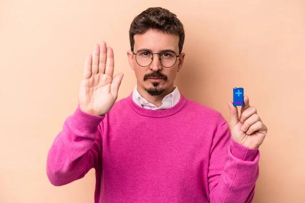 Mladý Běloch Který Drží Baterie Izolované Béžovém Pozadí Stojí Nataženou — Stock fotografie