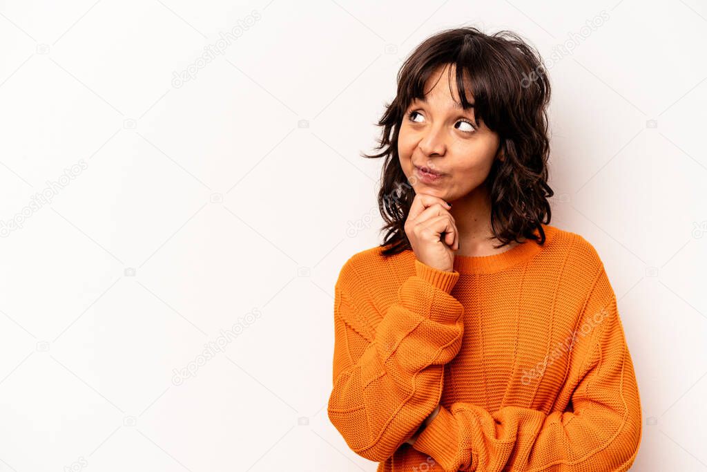 Young hispanic woman isolated on white background relaxed thinking about something looking at a copy space.