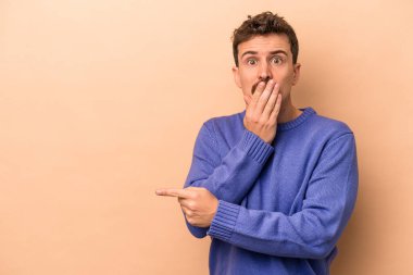 Beyazlı genç bir adam bej arka planda izole edilmiş.