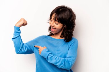 Young hispanic woman isolated on white background showing strength gesture with arms, symbol of feminine power