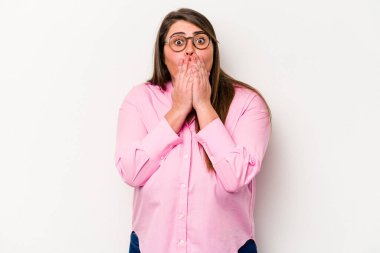 Beyaz arka planda izole edilmiş beyaz kilolu genç bir kadın elleriyle ağzını kapatırken şok oldu..