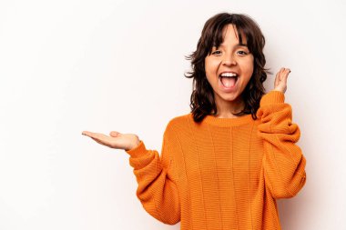 Beyaz arka planda izole edilmiş genç İspanyol kadın avuç içinde fotokopi alanı tutuyor, el üstünde tutuyor. Şaşırmış ve mutlu..