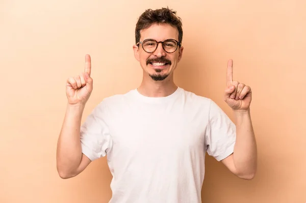 Young Caucasian Man Isolated Beige Background Indicates Both Fore Fingers — Stock Photo, Image