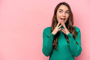 Kafkasyalı genç bir kadın pembe arka planda izole edilmiş bir plan yapıyor, bir fikir kuruyor..