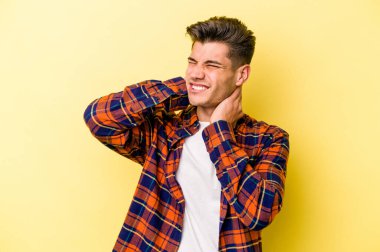 Sarı arka planda izole edilmiş genç beyaz adam sabit yaşam tarzından dolayı boyun ağrısından muzdarip..