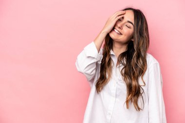 Pembe arka planda soyutlanmış genç beyaz kadın gülüyor, kaygısız, doğal duygu..