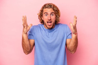 Pembe arka planda izole edilmiş genç beyaz adam gökyüzüne haykırıyor, yukarı bakıyor, hayal kırıklığına uğramış..