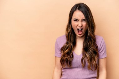 Beyazlı genç bir kadın bej arka planda izole edilmiş çok kızgın, öfkeli, hayal kırıklığına uğramış.