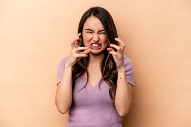 Bej arka planda izole edilmiş genç beyaz kadın gergin elleriyle çığlık atıyor..