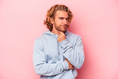 Pembe arka planda izole edilmiş genç beyaz adam virüs veya enfeksiyon yüzünden boğazında ağrı hissediyor..