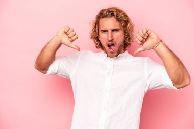 Pembe arka planda izole edilmiş genç beyaz adam gururlu ve kendinden emin hissediyor, örnek olarak.