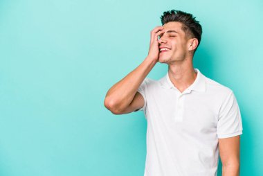 Kafkasyalı genç adam mavi arka planda yalnızdı gülerek, kaygısızca, doğal duygularla.