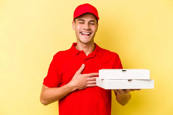 Young Delivery Caucasian Man Holding Pizzas Isolated Yellow Background Laughs — ストック写真