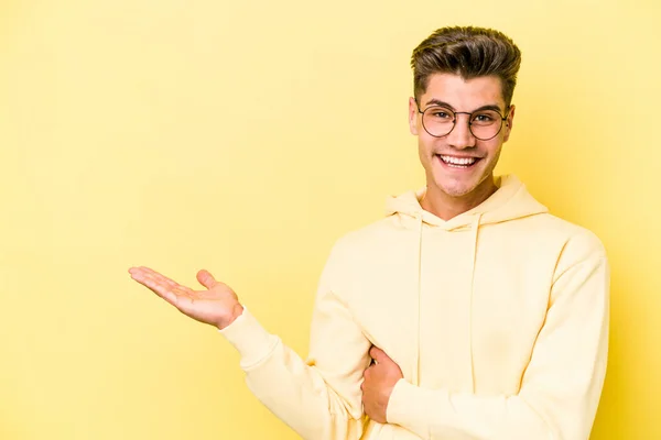 Jonge Blanke Man Geïsoleerd Gele Achtergrond Toont Een Kopieerruimte Een — Stockfoto